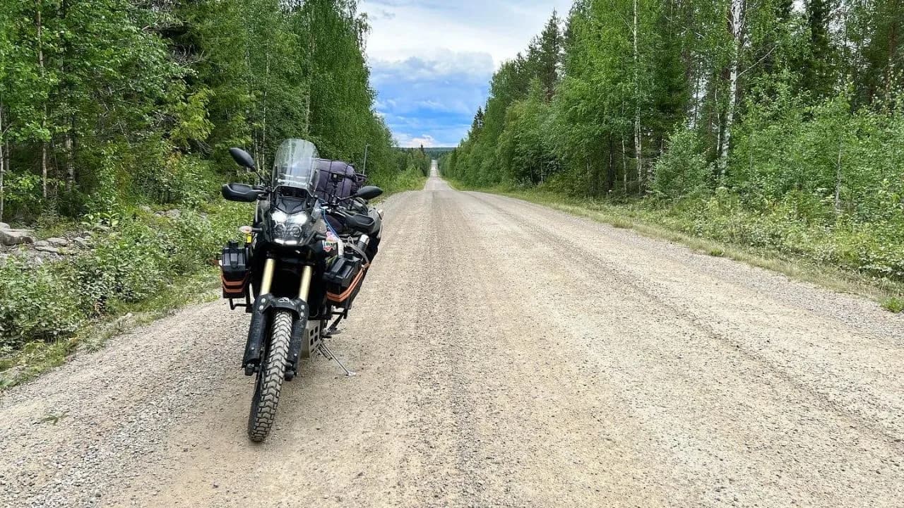 Carretera de grava recta cruzando un espeso bosque de taiga boreal