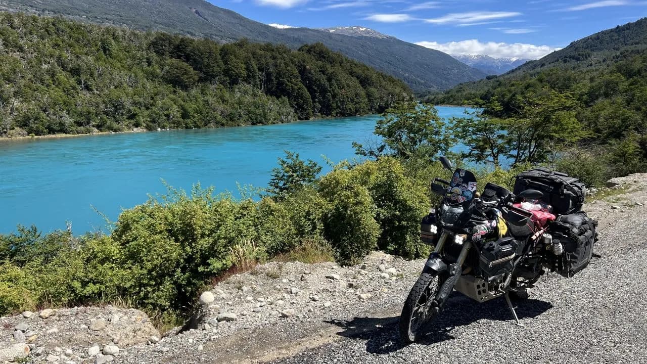 Adventure motorcycle next to the powerful turquoise Baker River