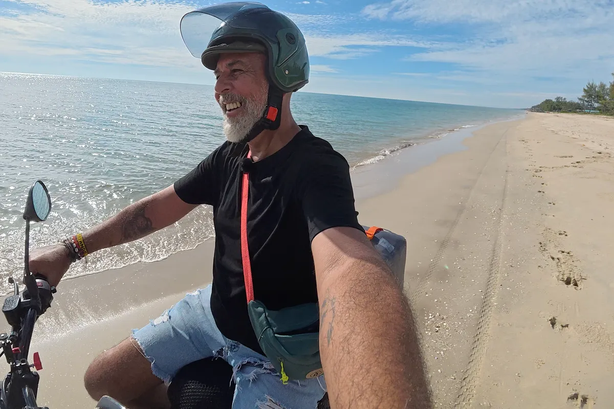 Moto de baja cilindrada aparcada en una playa desierta del sur de Tailandia