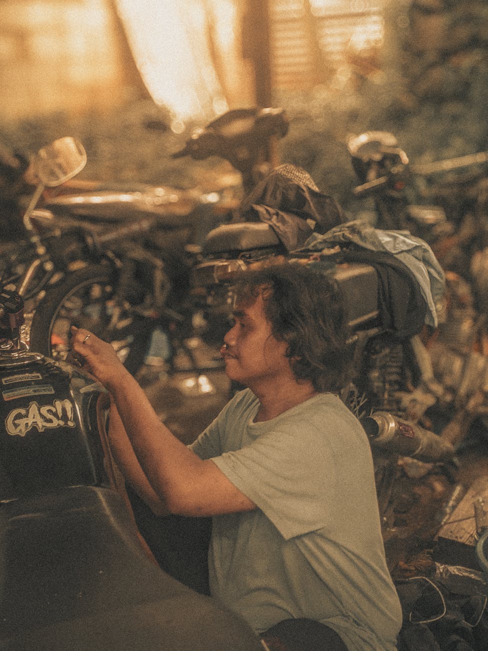 man repairing motorcycle in indonesian workshop