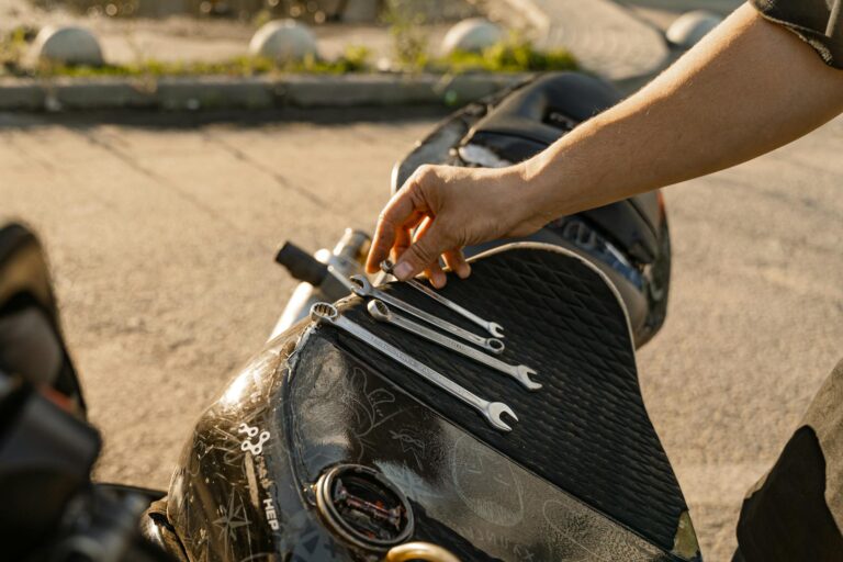 man hand holding wrenches on motorbike